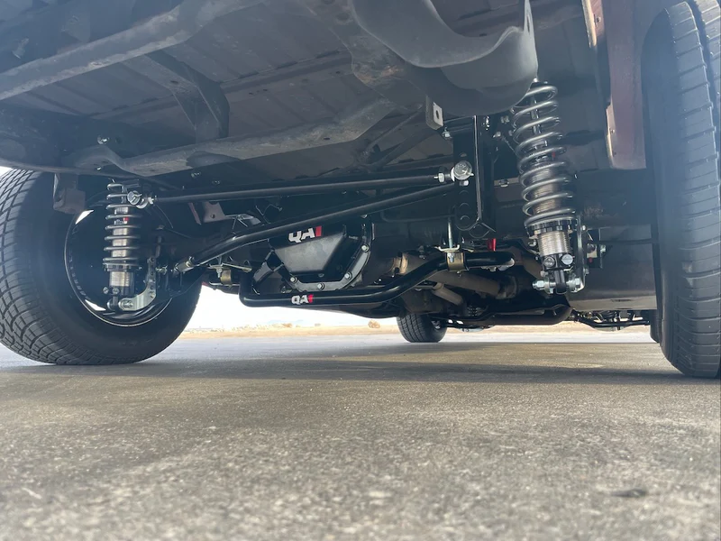 Custom QA1 coilover suspension setup on a frame-swapped C10 — adjustable shocks, custom crossmember, sway bar